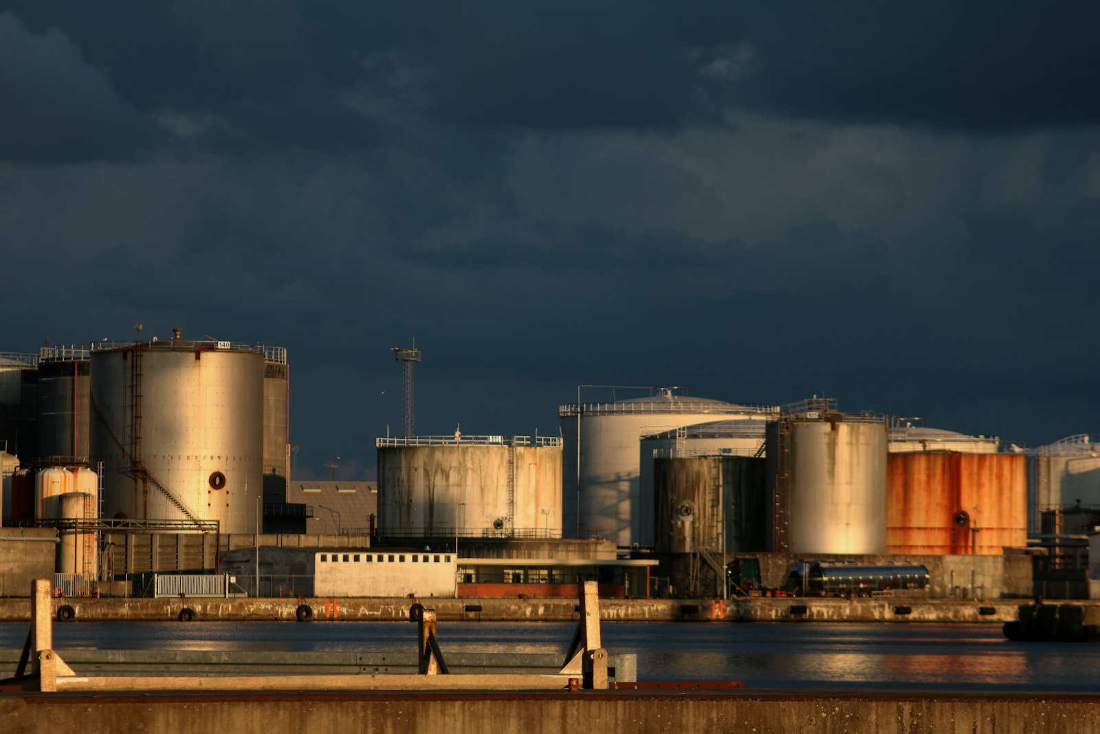 Industrial storage tanks under dramatic light